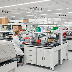 A person in a white coat in a lab.